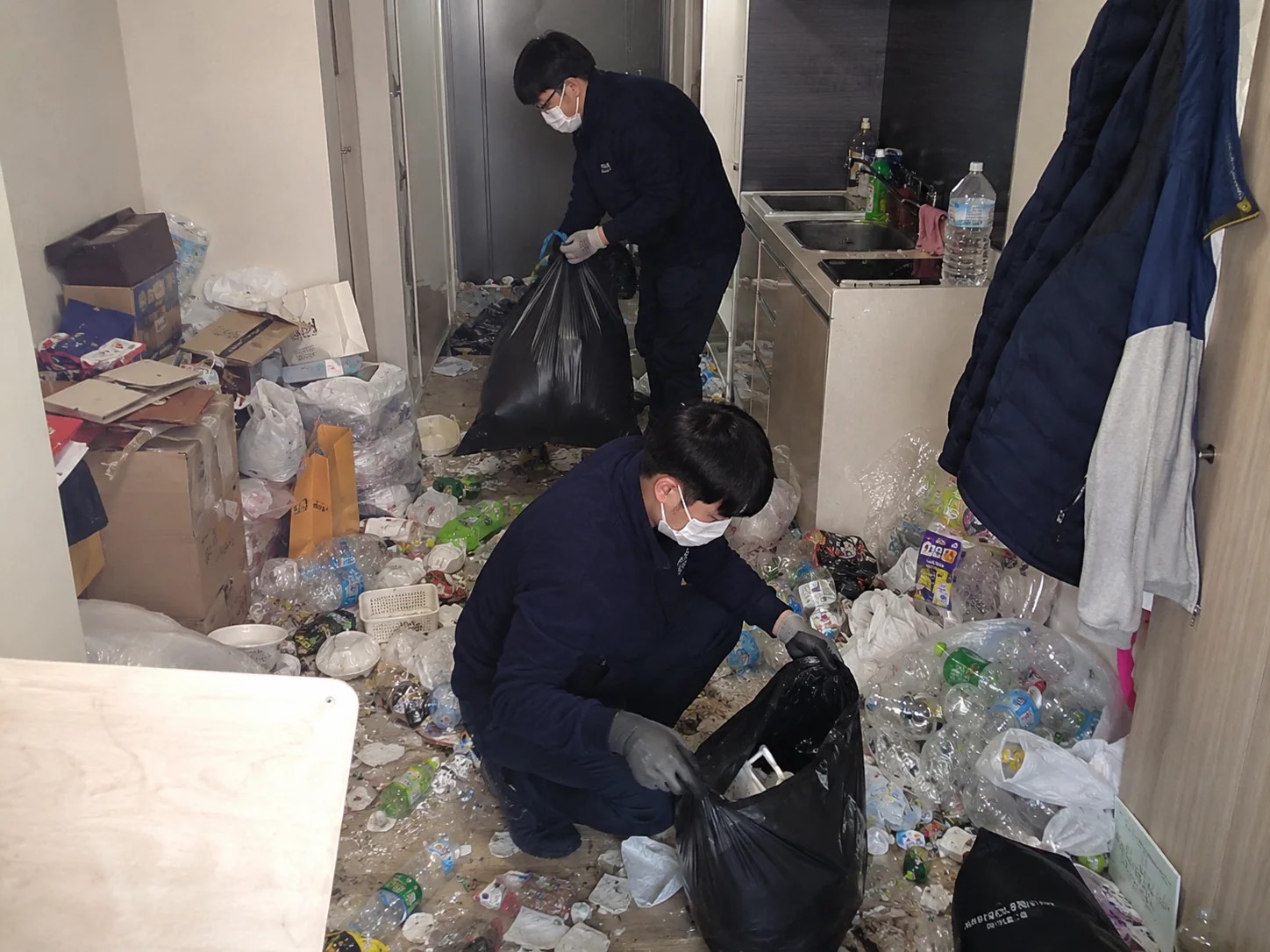 주거공간의 대량 폐기물을 수거하는 작업자
